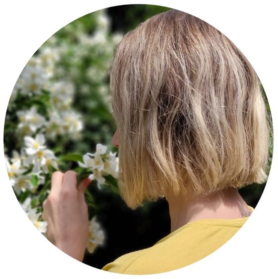 Mia Peters mit einer zarten Blüte in der Hand